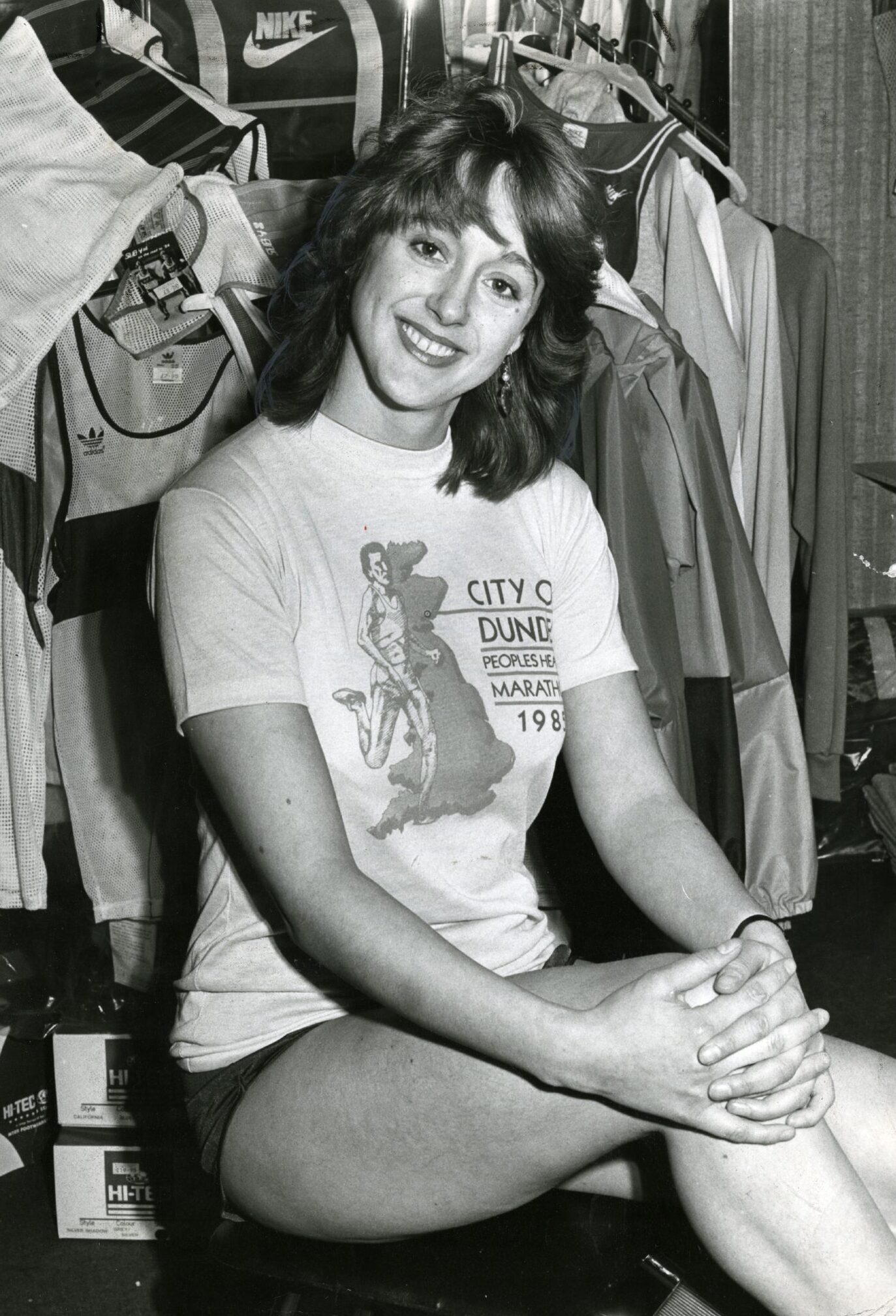 Caroline Headley modelling the Dundee marathon t-shirt while seated inside the shop in February 1985. 
