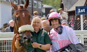 a woman and a jockey pose with a horse at one of Perth racing fixtures
