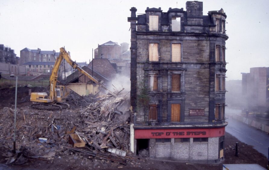 A digger pulling debris from the back of the bar. 
