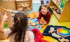 Boy laughing as he plays on floor in Psychology Kindergarten