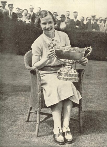 Jessie Valentine as a young woman, smiling holding large trophy