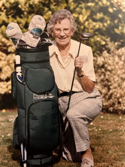 Jessie Valentine kneeling beside a golf bag