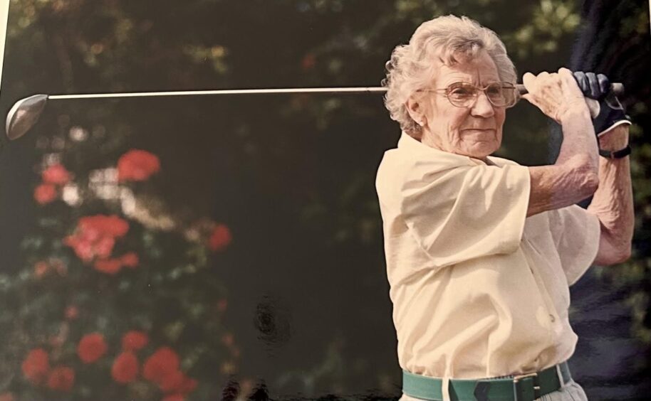Jessie Valentine as an older lady swinging a golf club