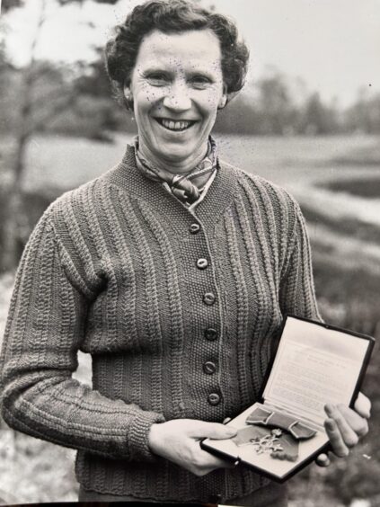 Black and white photo of Jessie Valentine holding MBE medal