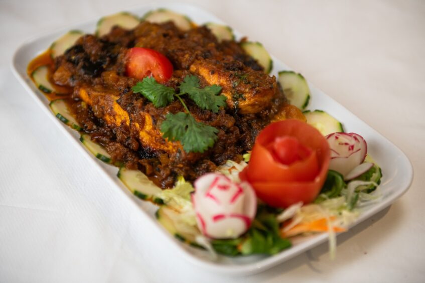 A brown curry with an elaborate garnish.