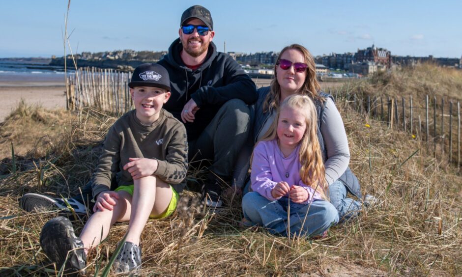 Image shows: The Monro family on West Sands beach in St Andrews. The family of four are sitting amongst the dunes at the beach.Dad Stuart and mum Megan are behind their children Finlay, 10, and Mia, 6. They are relaxed and smiling at the camera.