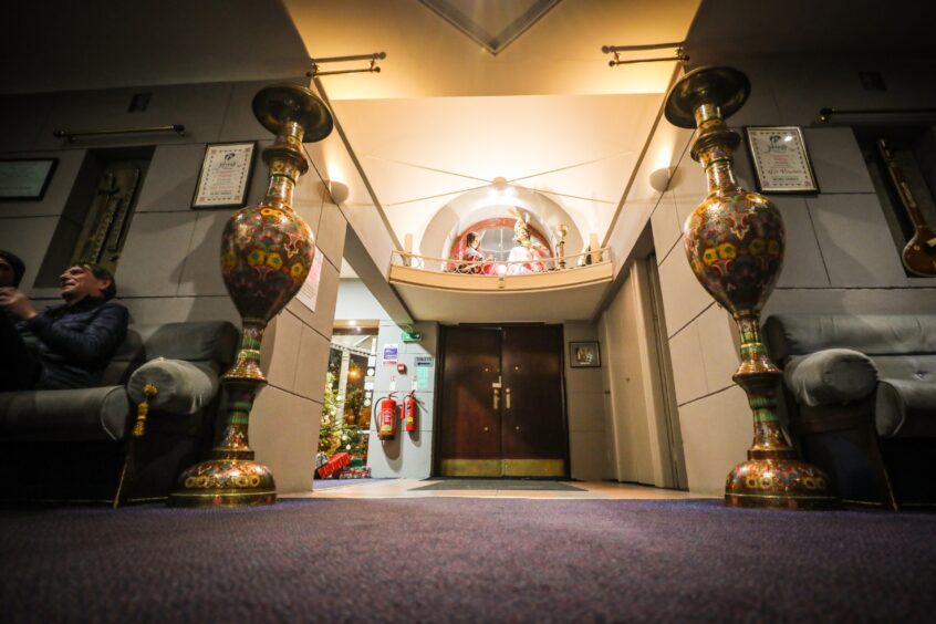 Two large ornate vases stand either side of the wooden doors that lead into Jahangir restaurant