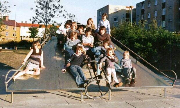 Children on the chute in the playground of the South Road multis in Lochee.