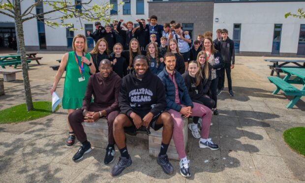 Mo Sylla, Billy Koumetio and Ziyad Larkeche with teachers Katherine Irvine (left), Hope Gaffney (back right) and Carnoustie High youngsters. Image: Steve MacDougall/DC Thomson
