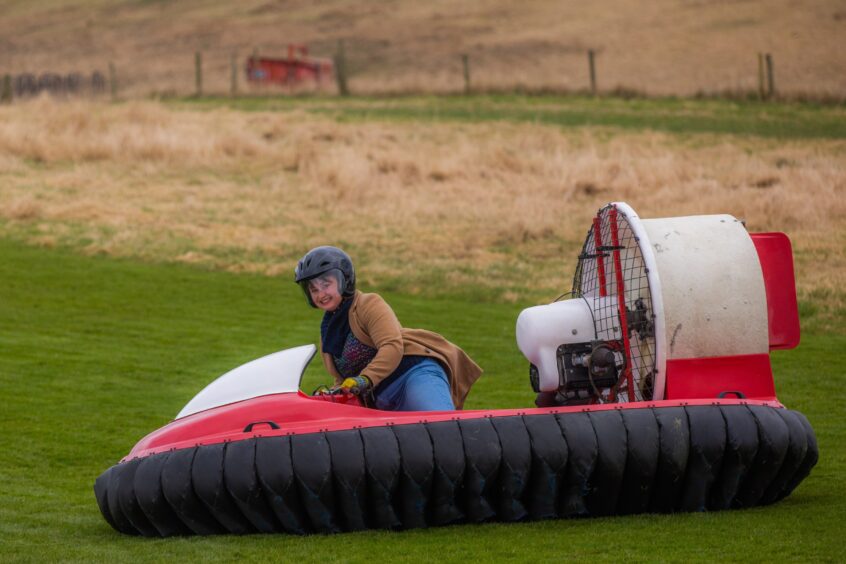 Rebecca Baird smiles at the camera while riding a hovercraft. 