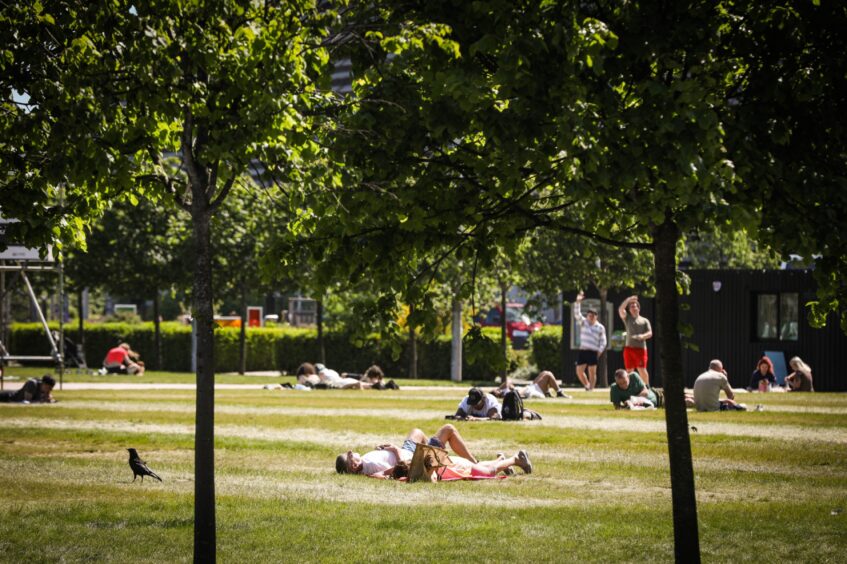 People enjoying sunny weather in an Dundee park