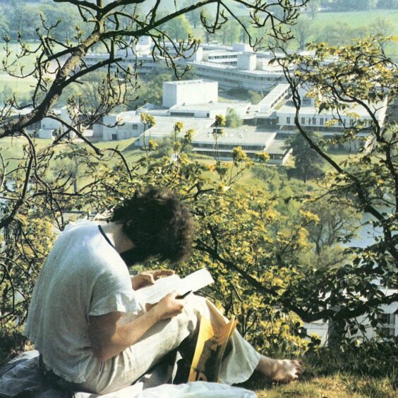 image shows: the cover image from the Stirling University prospectus from 1982. A sunny picture of a student overlooking the campus buildings.