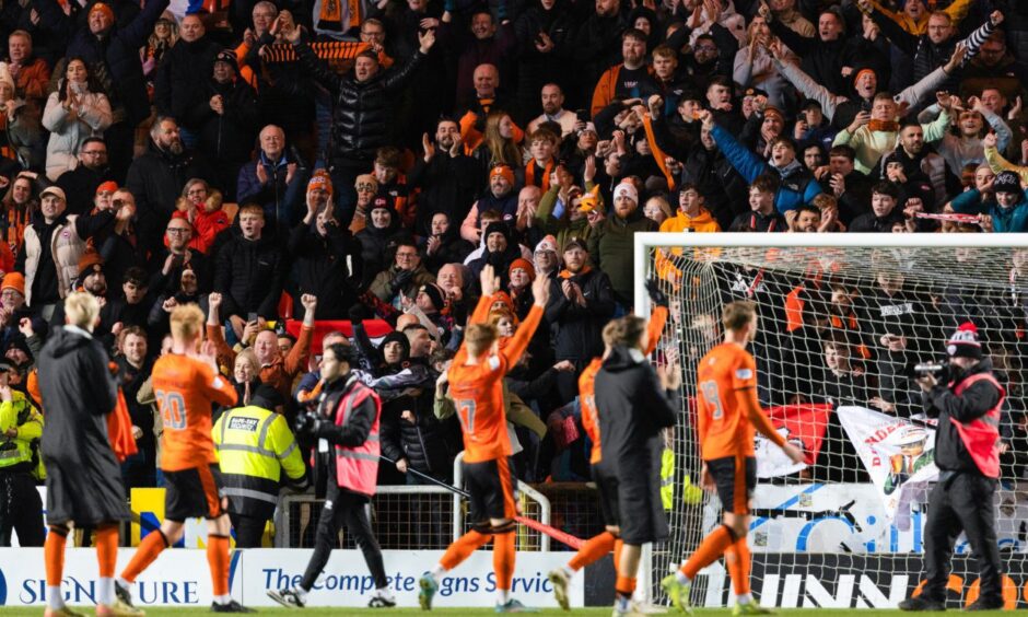 Dundee United fans clap the players as they walk round the pitch.
