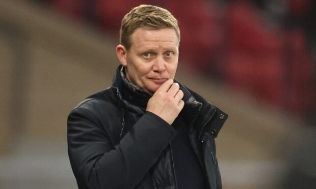 Raith Rovers manager Barry Robson holds his right hand up to his face in pensive mood.
