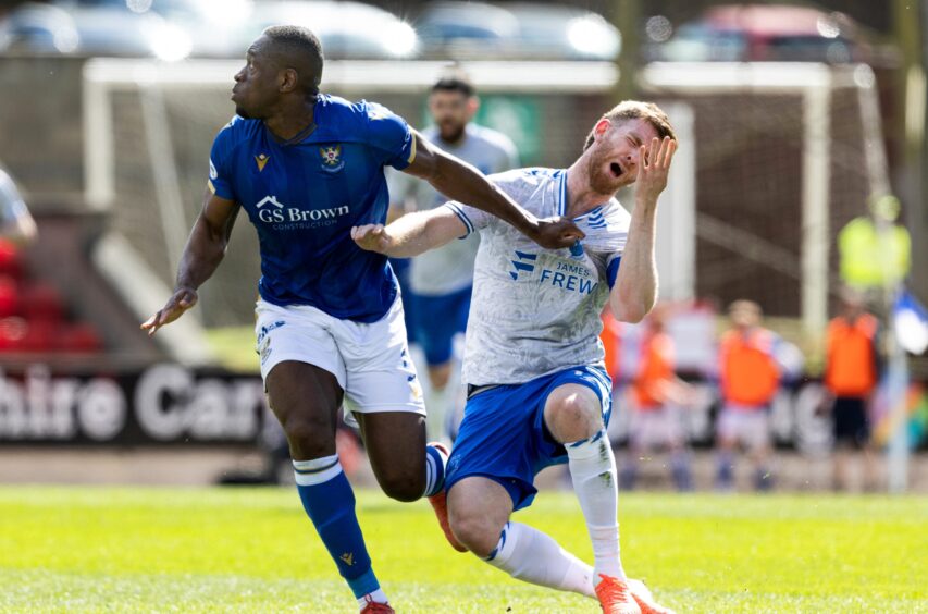 Uche Ikpeazu holds off a Kilmarnock player.