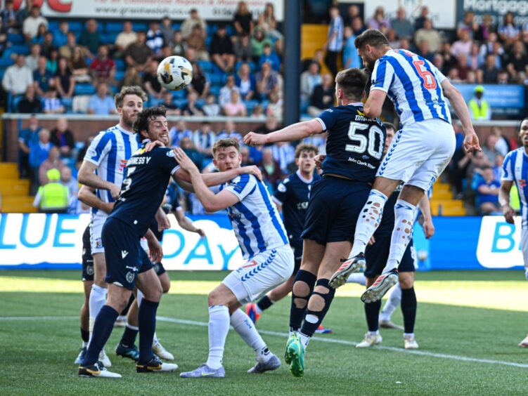 Dundee defender Aaron Donnelly is out-jumped by Robbie Deas as the Kilmarnock player wins a header to score.