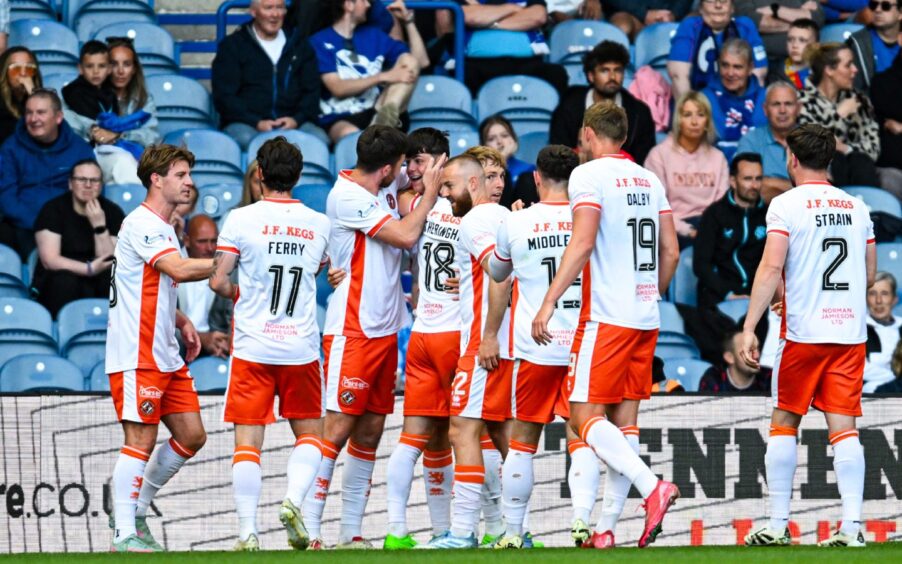 Sam Cleall-Harding is mobbed after opening his Dundee United account