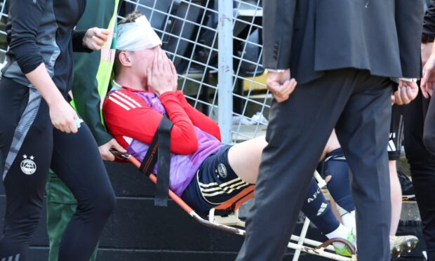 Aberdeen defender Jack MacKenzie receives treatment after the incident. Image: Roddy Scott / SNS Group)