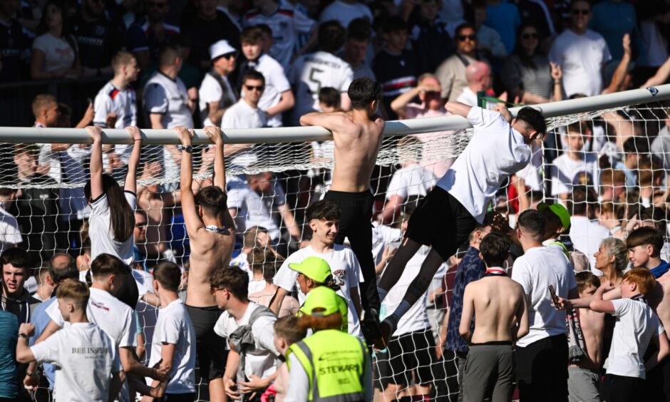 Dundee fans climb on to crossbar at McDiarmid Park at full-time. Image: Paul Devlin/SNS Group