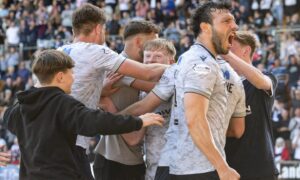 Lyall Cameron is mobbed by team-mates and fans after securing victory over St Johnstone. Image: Paul Devlin/SNS