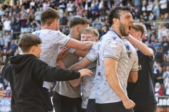 Lyall Cameron is mobbed by team-mates and fans after securing victory over St Johnstone. Image: Paul Devlin/SNS