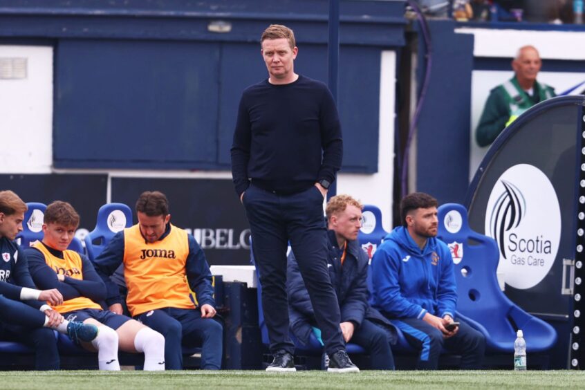 Raith Rovers boss Barry Robson stands with his hands in his pockets on the touchline.
