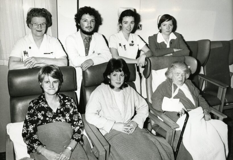 Four staff with three seated patients recovering from the rail crash. 