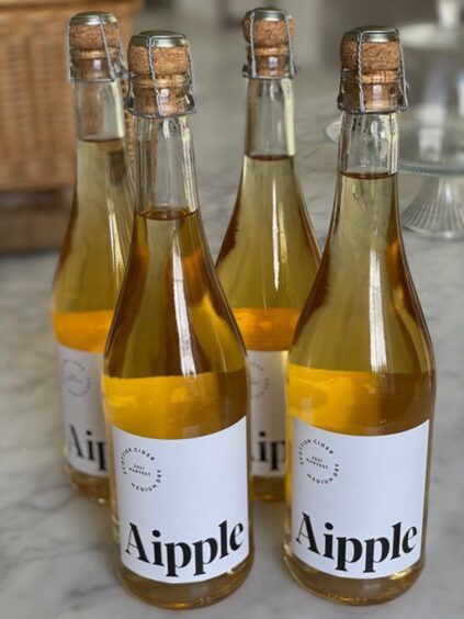 Bottles of cider sitting on a table.