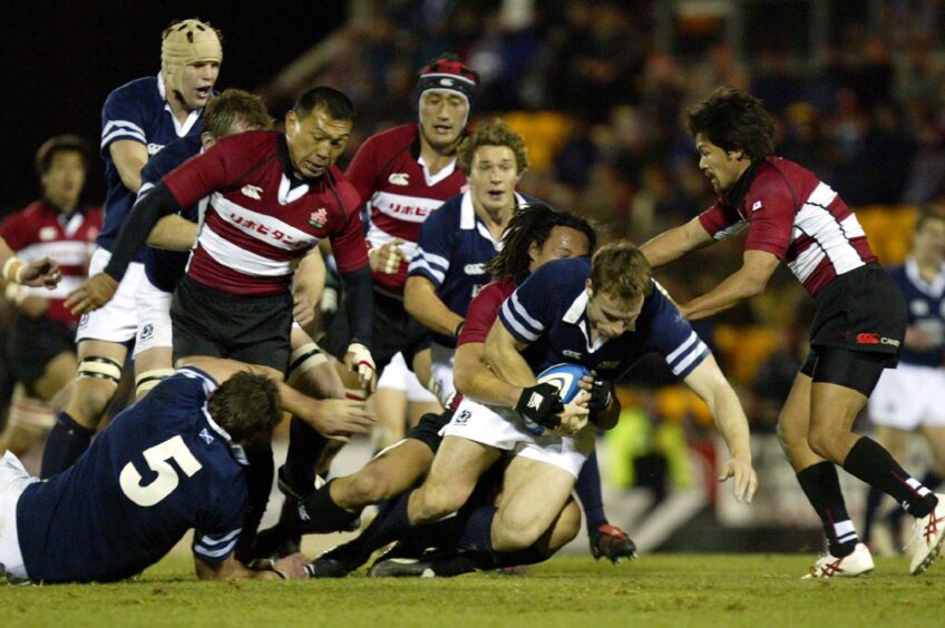 Scotland's Andy Henderson is tackled by Hideyuki Yoshida during the rugby international against Japan at McDiarmid Park in November 2004.