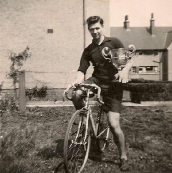 A young Bill Shewan on his bike with a trophy.