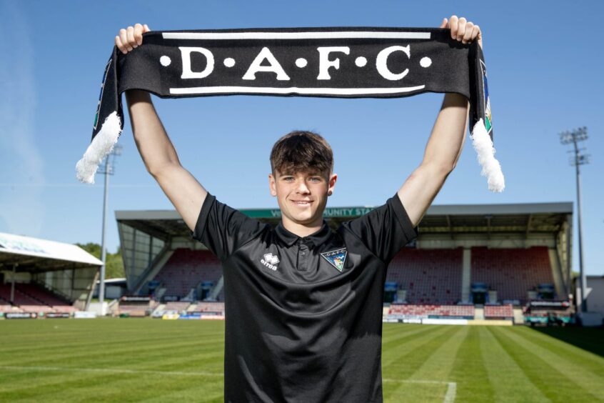 Lucas Fyfe holds a DAFC scarf above his head at Dunfermline's East End Park.
