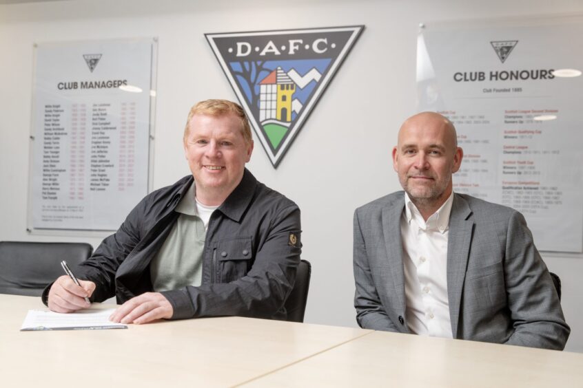 Neil Lennon sits beside chairman and CEO David Cook as he signs his new DAFC contract.