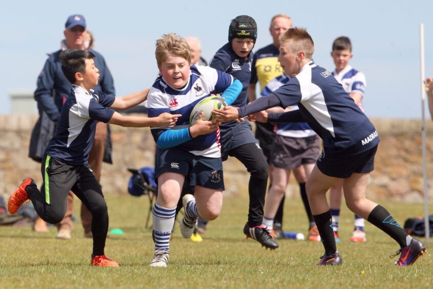 Madras players trying to stop a Howe of Fife player from scoring