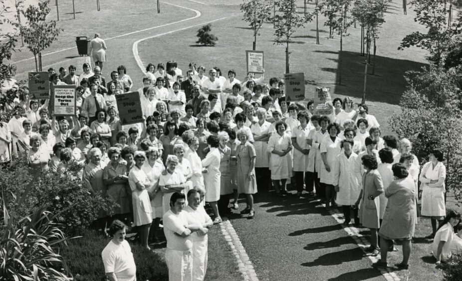 Nurses join staff in holding placards outside Ninewells Hospital as part of in a demonstration in July 1980.