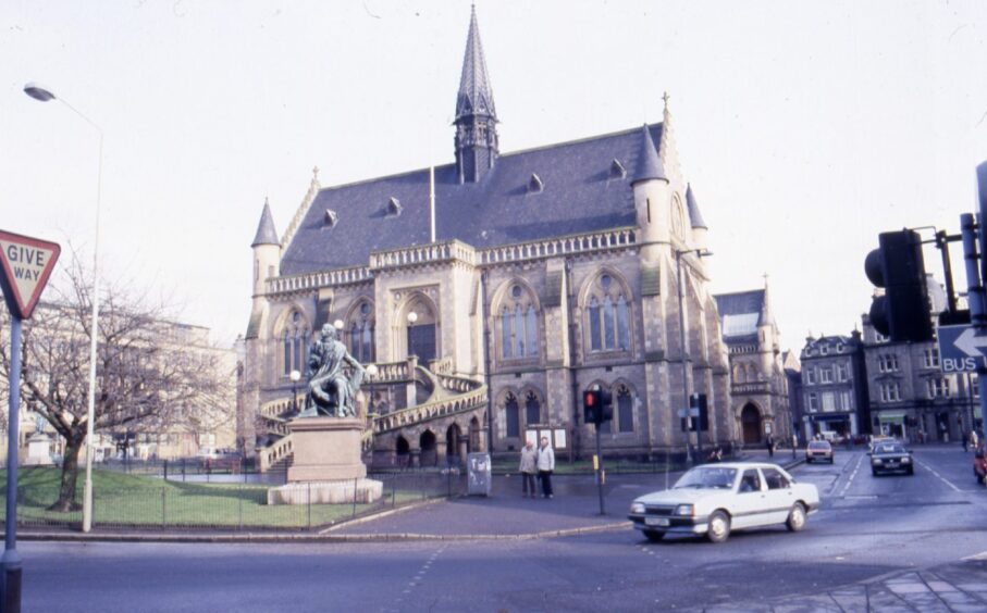 Cars driving past Dundee museum the McManus Galleries.