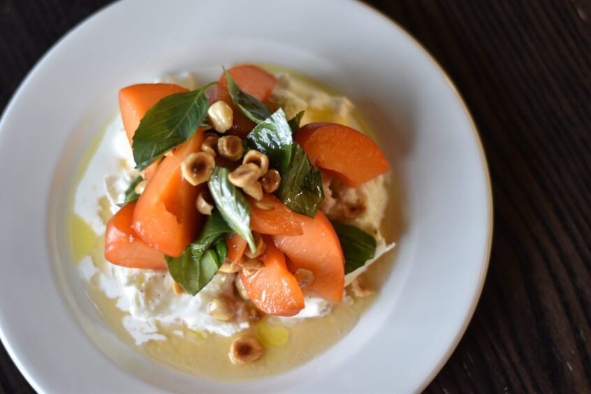 A peach and mozzarella starter served on a plate.
