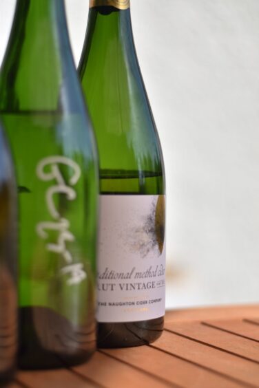 Bottles of cider sitting on a table.