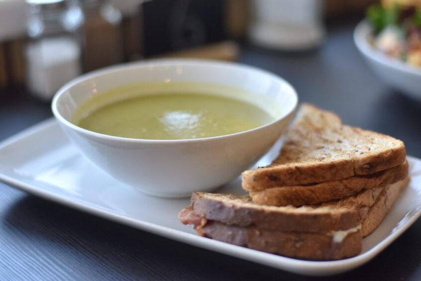 A toastie and a bowl of souped served in a café. 