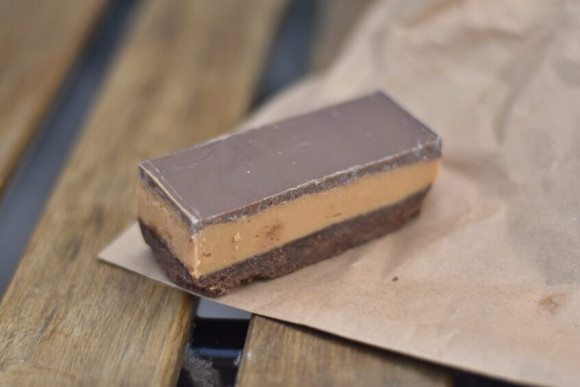 A chocolate and caramel traybake, sitting on a table.