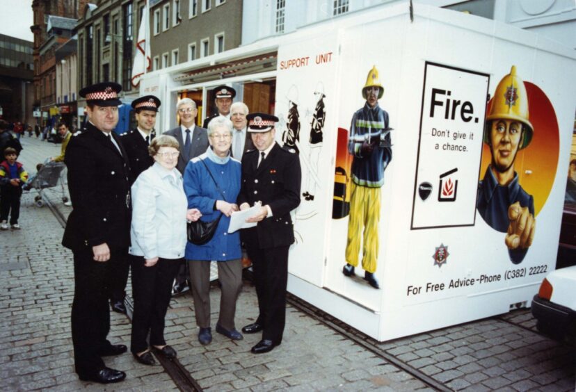 Firefighters with members of the public outside an information stall in Dundee's Murraygate.