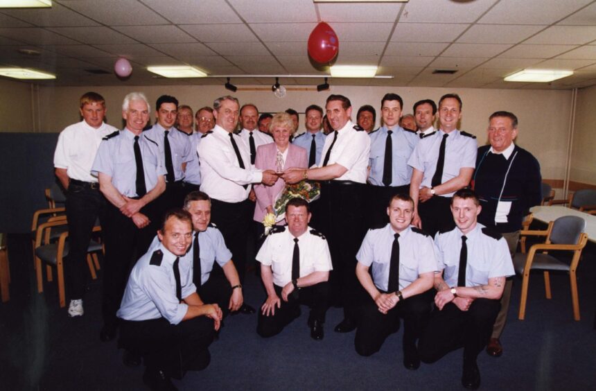 a large group of firefighters pictured at the presentation in a hall