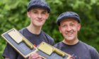 Ben and Richard Megahy smiling holding Butcher Wards trophy