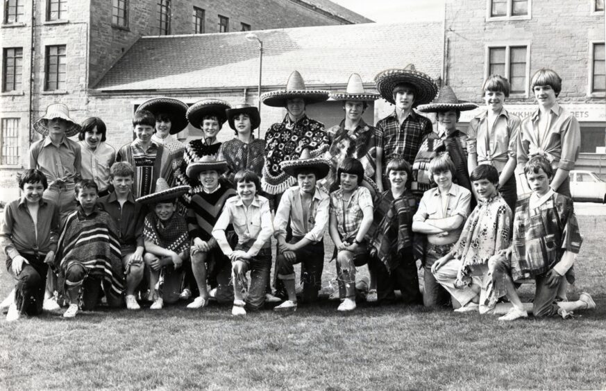 Youngsters wearing ponchos and sombreros taking part in a Mexican scene in the April 1982 Gang Show production.