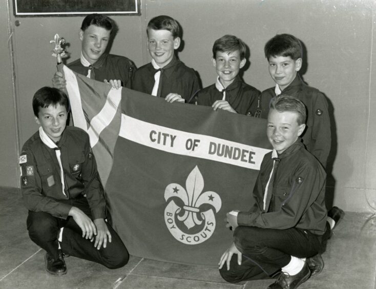 Six members of the 45th Dundee Scouts (Broughty Ferry) with the flag.