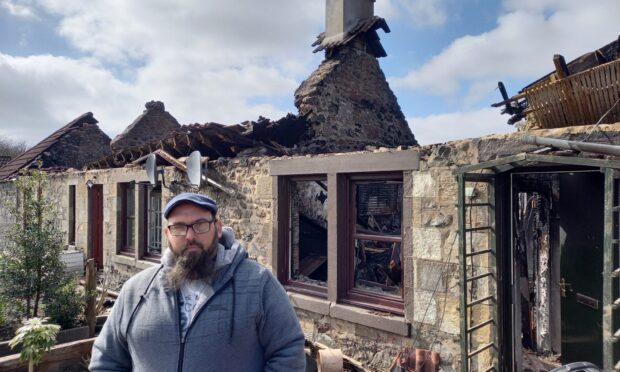Gareth Parsons outside the fire gutted remains of his cottage at Grange of Lindores. Image: Michael Alexander