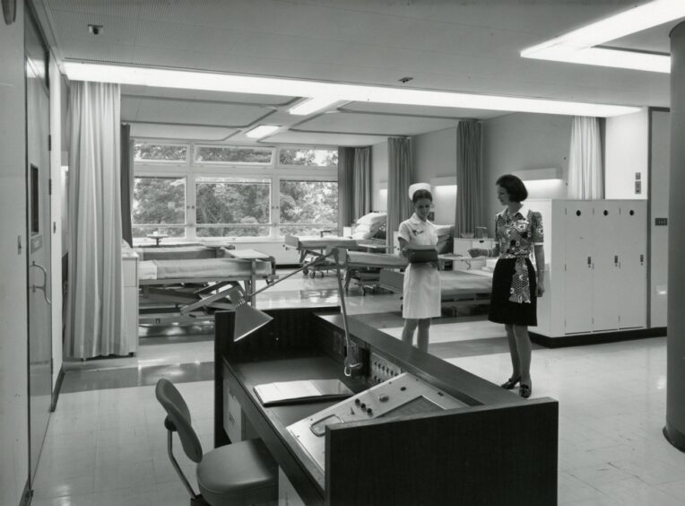 A nurse and staff member standing in a corridor in January 1974