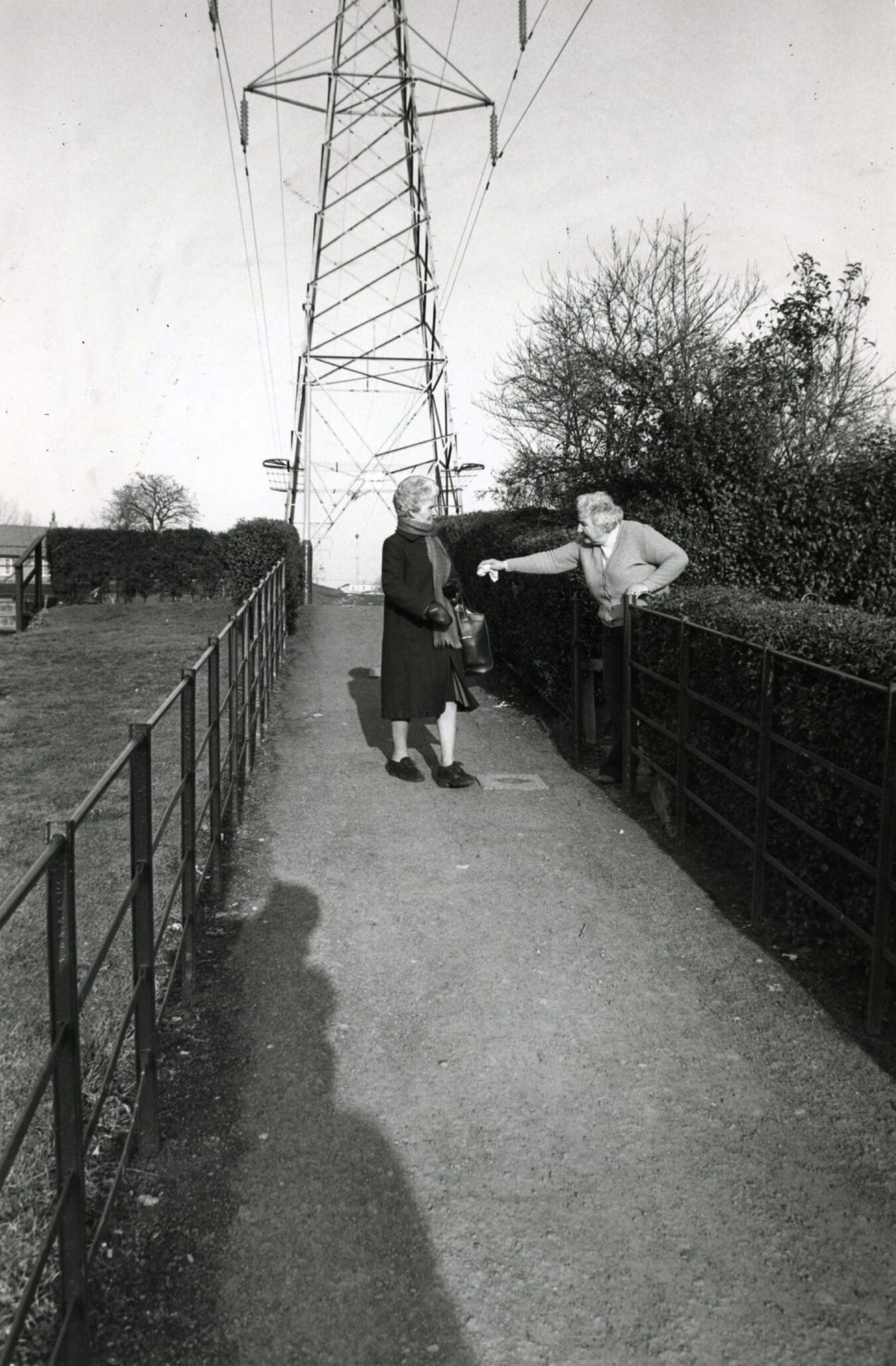 Pensioner Pearl Cosans motions to a friend at the footpath in 1983. 