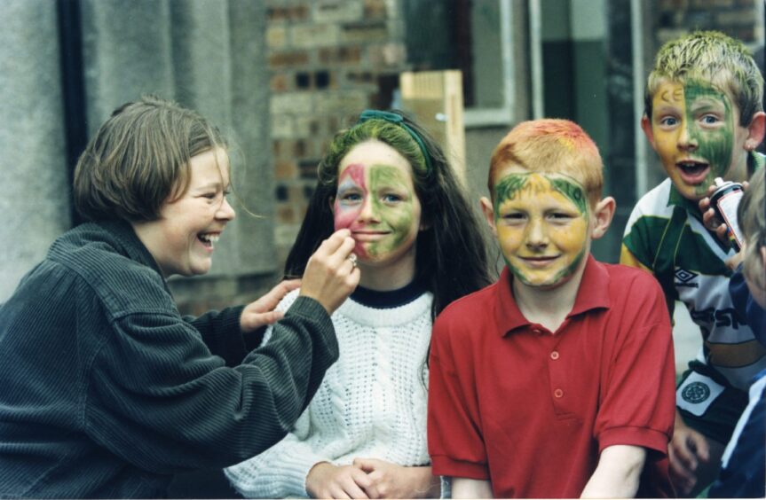 three youngsters get their face painted