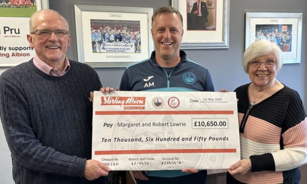 Stirling Albion manager Alan Maybury handing over the lottery winners cheque to Margaret and Robert Lawrie.