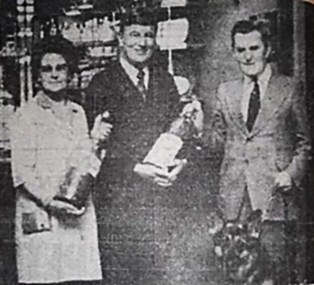 John and wife Maisie handing over a donation to Alex Duguid from Guide Dogs. 